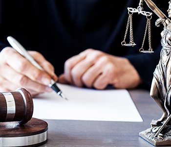 A lawyer's hand writing notes on a legal document